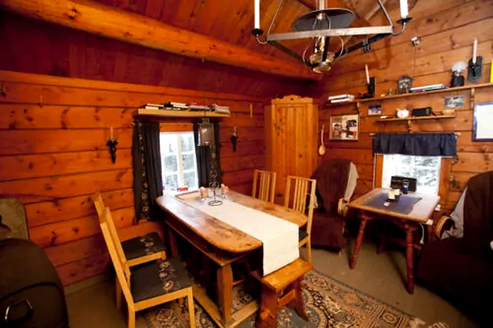 Simple wooden living and dining area inside the Red Cabin